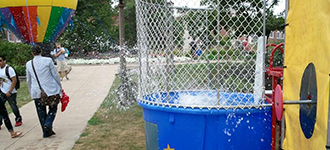 Action shot of someone falling into the dunk tank at Festival ISU