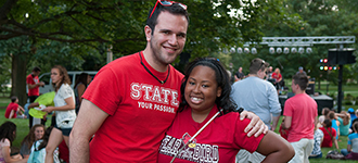 Male and female student posing at outdoor activity in ISU gear