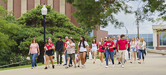 A group of students walking on a campus pathway during  preview